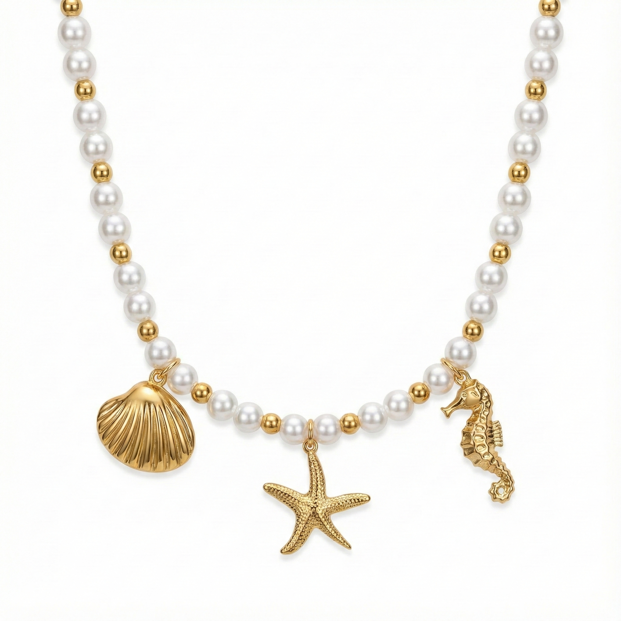 Collier tendance à charms marins : accumulation de breloques coquillages, étoiles de mer et perles sur chaîne dorée.